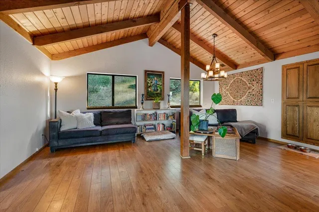 a living room with furniture a wooden floor and next to a window