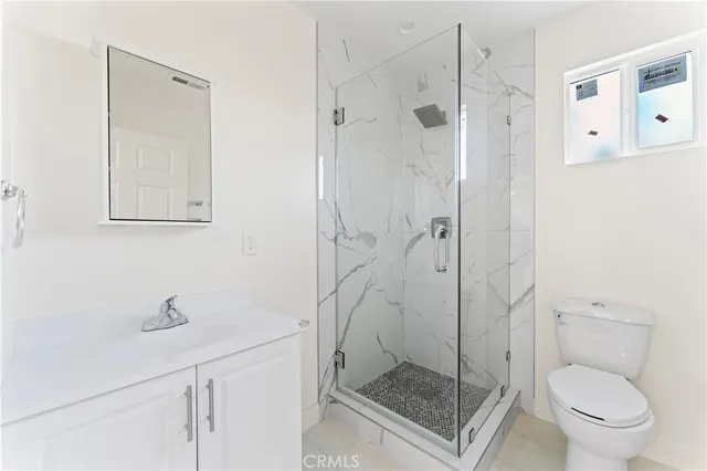 a bathroom with a shower a toilet and a sink