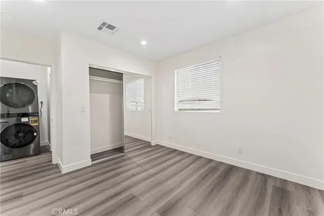 a view of a livingroom with wooden floor and closet area