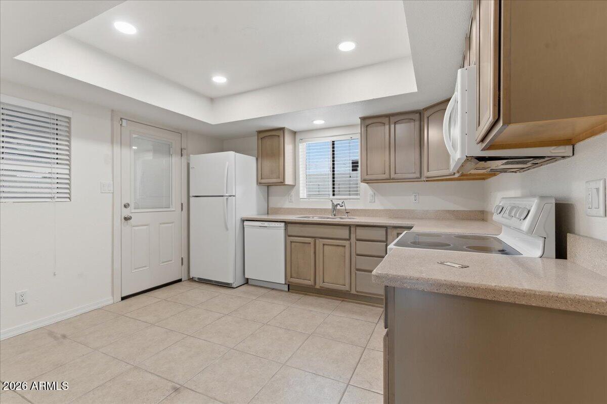 6512 North 12th Way Phoenix, AZ 85014 - Photo 9 of 39 a kitchen with a sink a refrigerator and cabinets