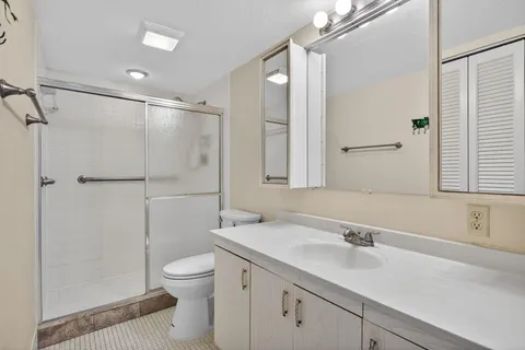 a bathroom with a sink toilet double vanity and shower