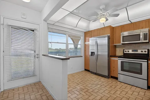 a kitchen with stainless steel appliances granite countertop a refrigerator and a stove