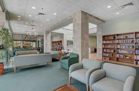 a living room with furniture and a book shelf