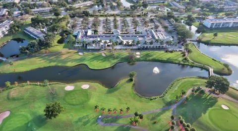 an aerial view of a residential houses with outdoor space and a lake view