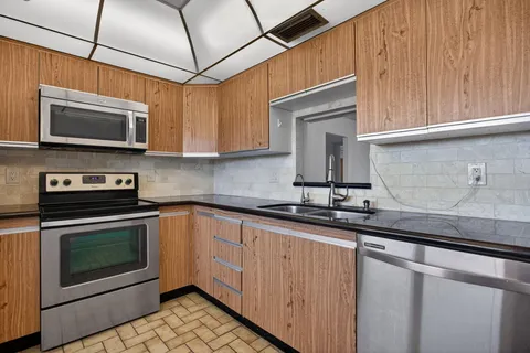a kitchen with stainless steel appliances granite countertop a stove microwave and cabinets