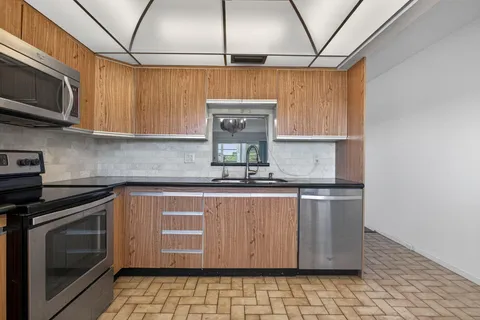 a kitchen with stainless steel appliances granite countertop a sink a stove a microwave and cabinets