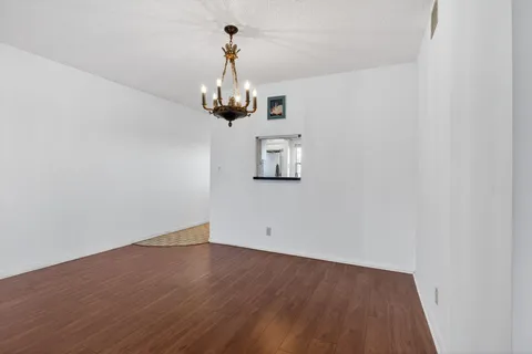 a view of a room with wooden floor and ceiling fan