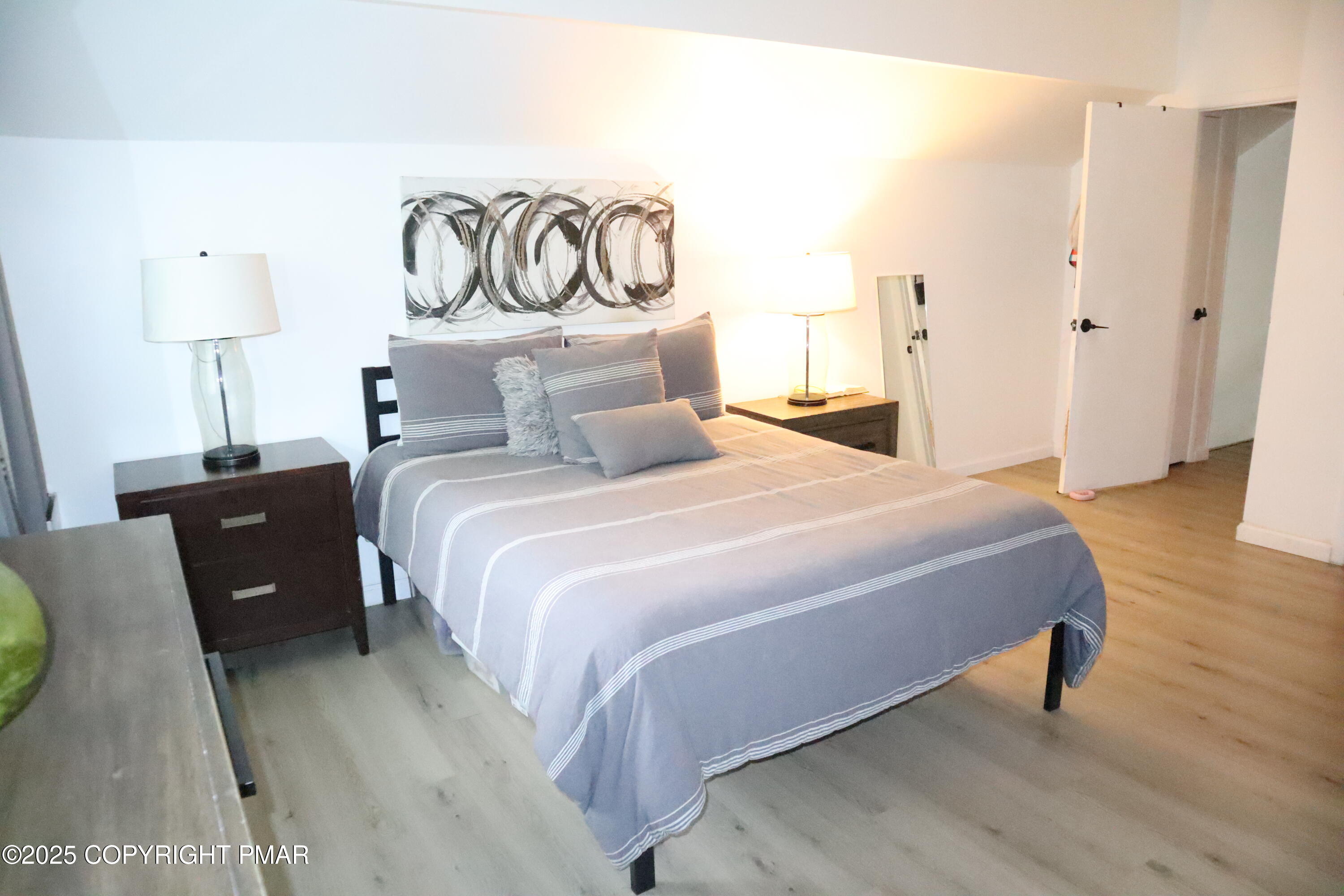 2116 Bobolink Trail Bushkill, PA 18324 - Photo 11 of 19 a bedroom with a bed and a lamp on table