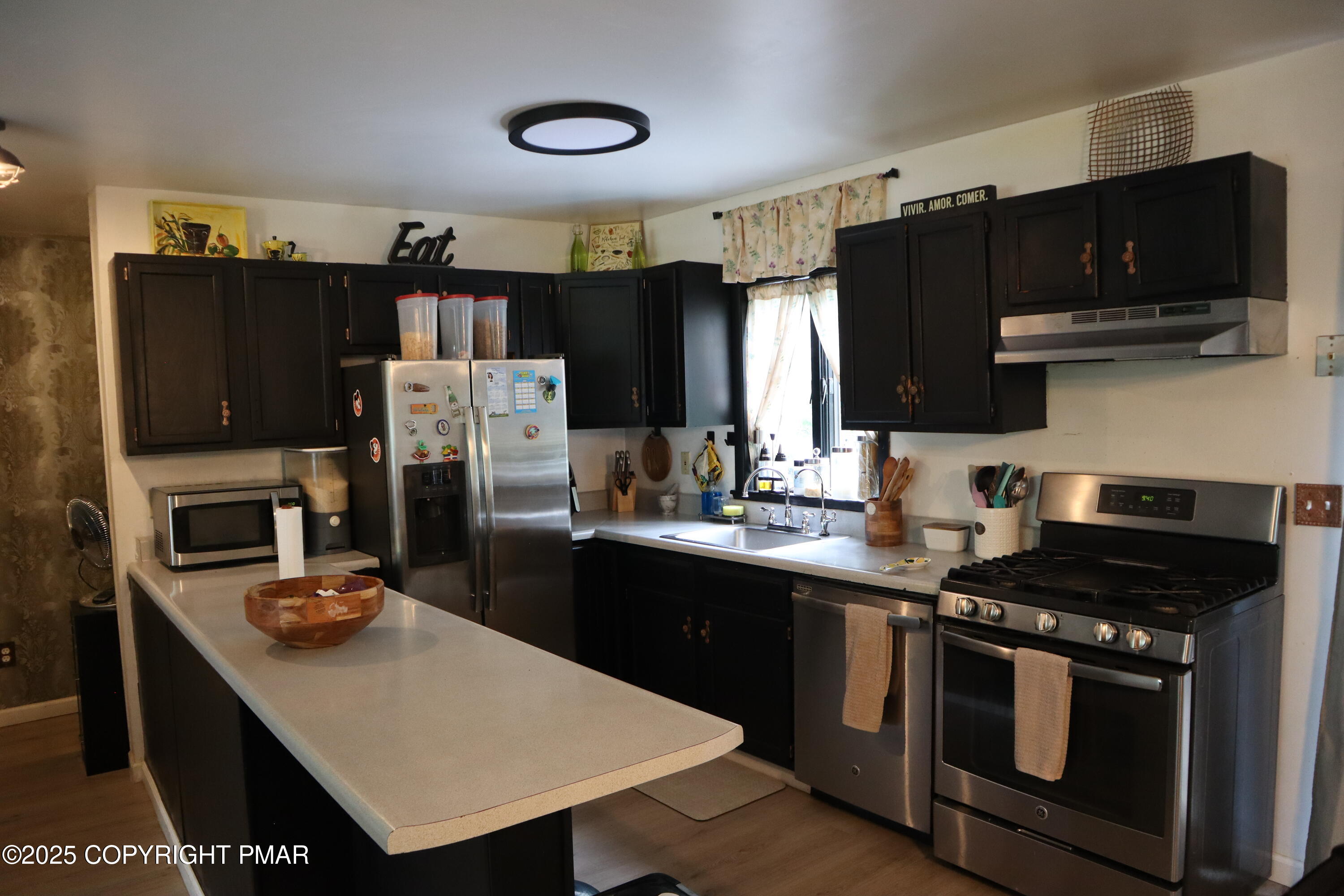 2116 Bobolink Trail Bushkill, PA 18324 - Photo 6 of 19 a kitchen with stainless steel appliances a stove refrigerator sink and microwave