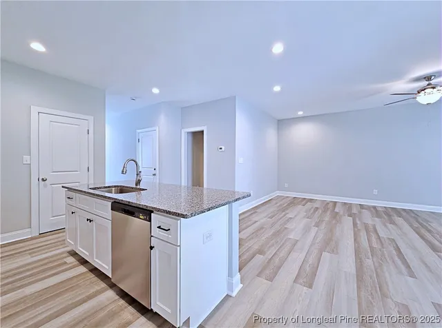 a kitchen with granite countertop a sink and cabinets