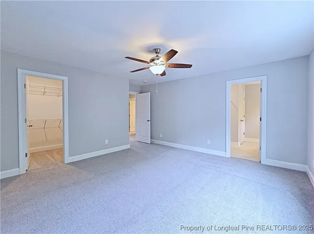 a view of an empty room with a ceiling fan