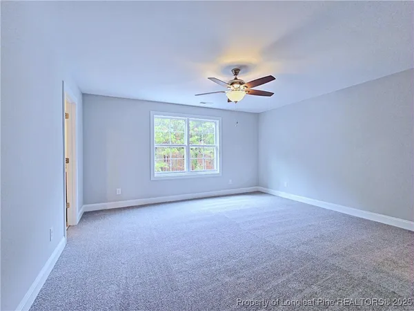 an empty room with closet and fan