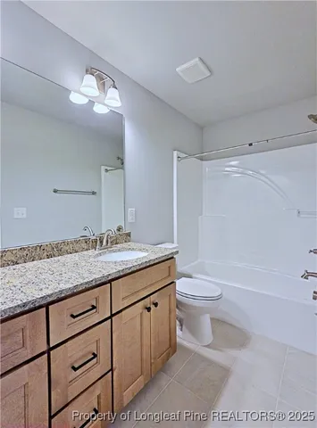 a bathroom with a granite countertop sink a toilet and a bathtub