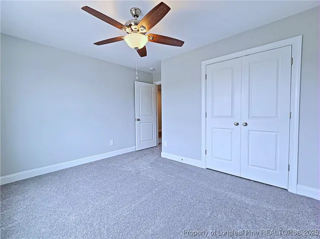 an empty room with closet and fan