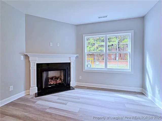 a living room with a fireplace with wooden floor
