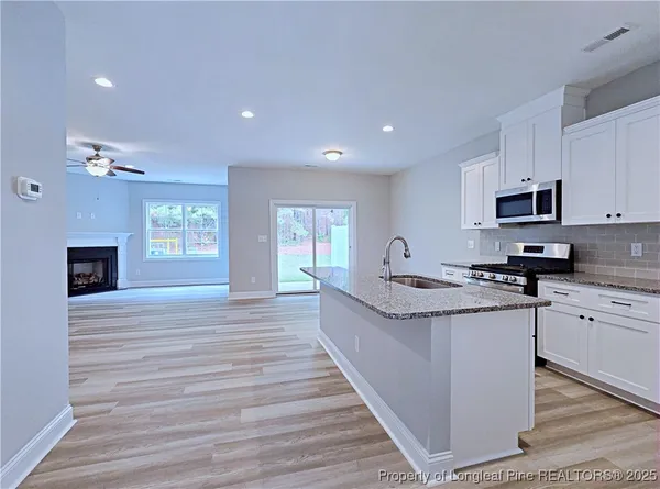 a large kitchen with cabinets wooden floor and stainless steel appliances