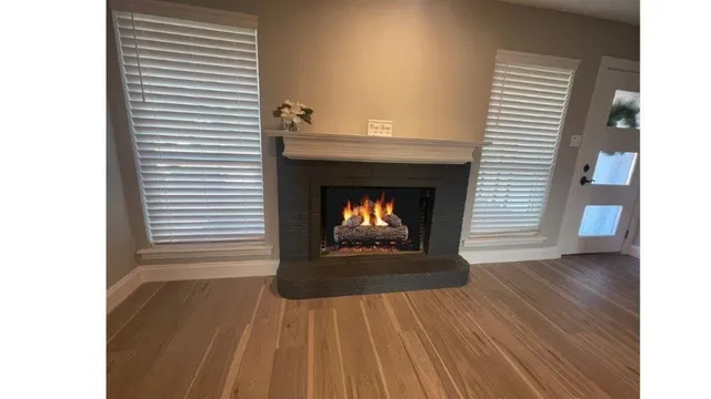 a view of a livingroom with a fireplace and wooden floor