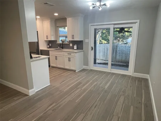 a kitchen with a refrigerator a stove cabinets and wooden floor