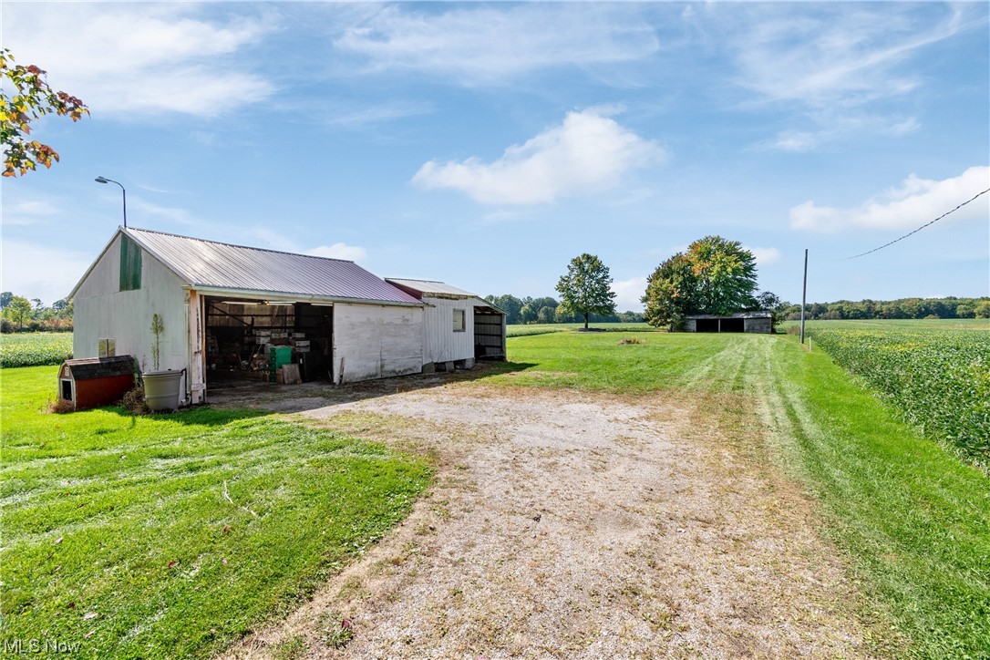 This outbuilding is in the back of the farmhouse. Another quonset type building is seen at the back and can be used for storage.