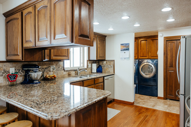 322 Bailey Creek Road Soda Springs, ID 83276 - Photo 8 of 32 Kitchen featuring wood cabinetry, granite-style countertops, mosaic tile backsplash, and a double basin sink with a window above