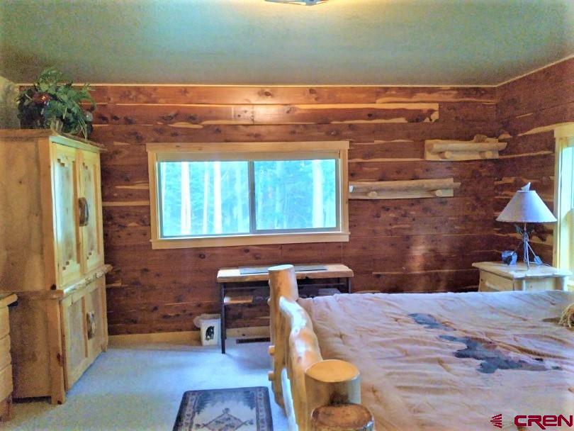 100 Crest Drive Cimarron, CO 81220 - Photo 13 of 35 a bedroom with a bed and wooden floor