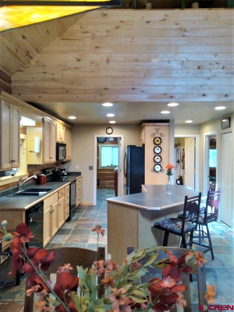 100 Crest Drive Cimarron, CO 81220 - Photo 8 of 35 a kitchen with stainless steel appliances granite countertop a sink dishwasher and a stove with wooden floor