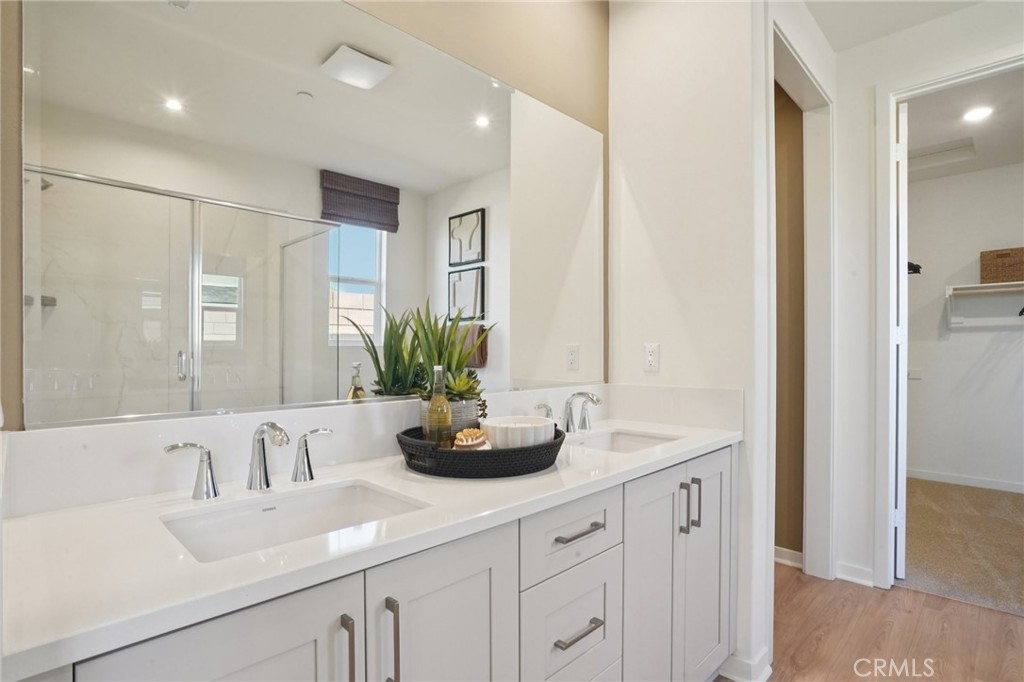 73550 Raphael Drive Palm Desert, CA 92211 - Photo 16 of 41 a bathroom with double vanity sinks a large mirror and a shower