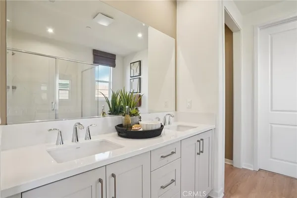 a bathroom with double vanity sinks a large mirror and a shower
