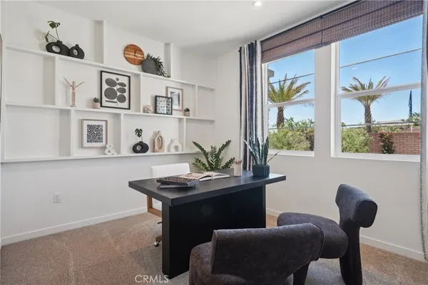a view of a workspace with furniture and window