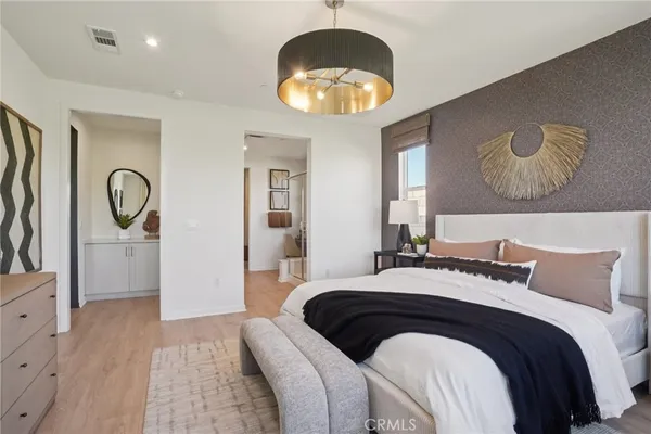 a bedroom with a bed and a chandelier