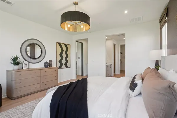 a bedroom with a bed and a chandelier