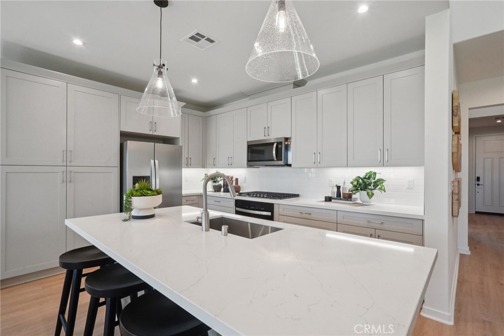 73550 Raphael Drive Palm Desert, CA 92211 - Photo 9 of 41 a kitchen with stainless steel appliances a white table chairs and a refrigerator
