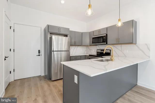 a kitchen with stainless steel appliances a refrigerator sink and microwave