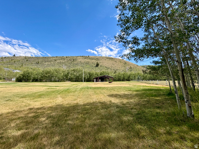 1133 Paris Canyon Road Paris, ID 83261 - Photo 37 of 75 Expansive green space featuring a large field with pavilion in the distance and a backdrop of a tree-covered hillside
