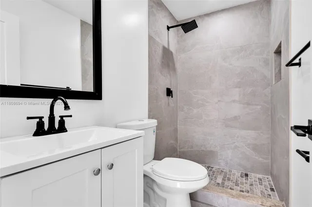 a bathroom with a sink a toilet and shower