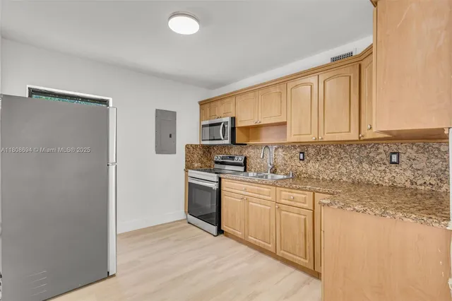 a kitchen with stainless steel appliances granite countertop a stove a sink and a refrigerator