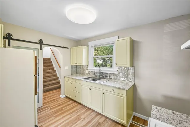 a view of a livingroom with wooden floor and a ceiling fan