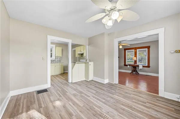 a kitchen with granite countertop a refrigerator and a wooden floor
