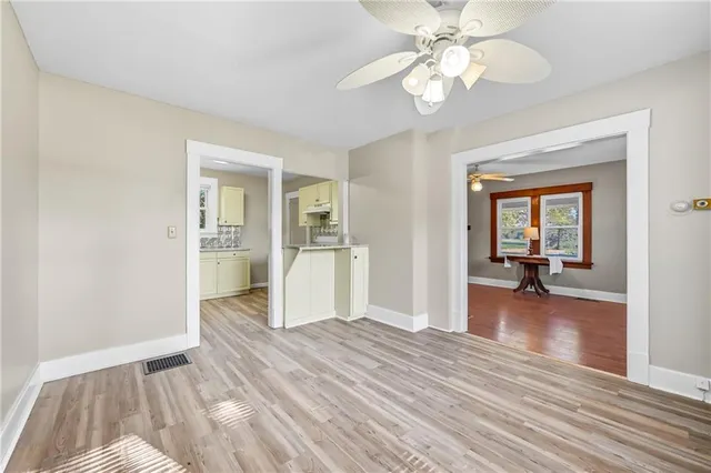 a kitchen with granite countertop a refrigerator and a wooden floor
