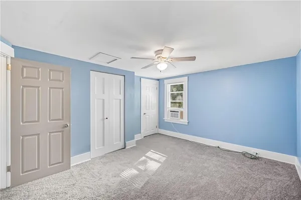 an empty room with a window and a ceiling fan