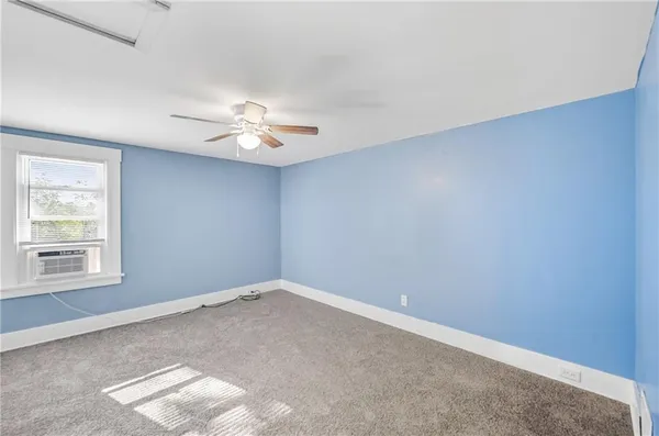 an empty room with closet and windows