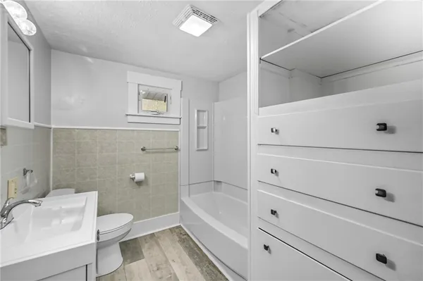 an empty room with closet and a ceiling fan