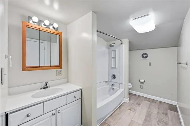 an empty room with windows and ceiling fan