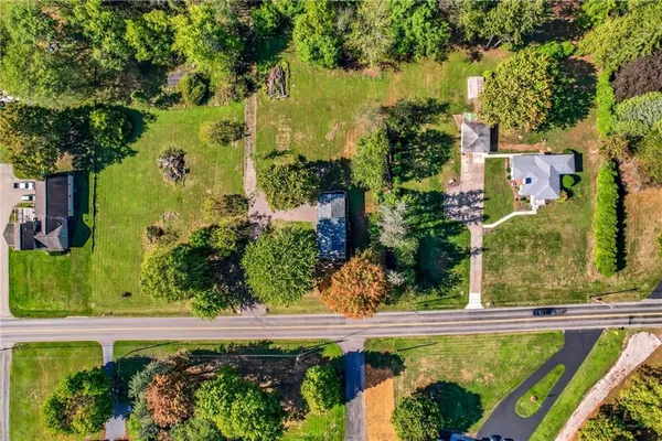 an aerial view of residential houses with outdoor space and trees