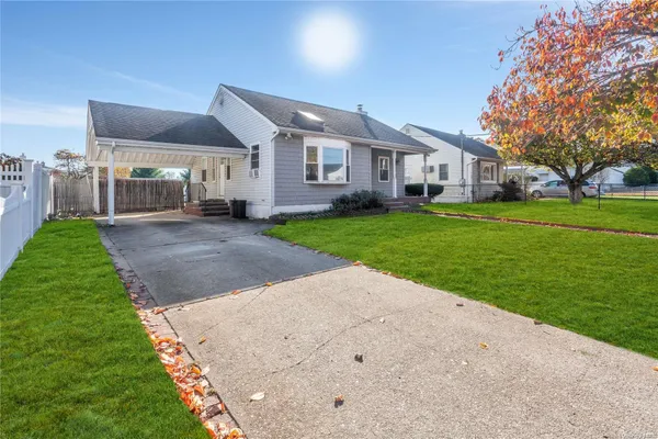 a front view of a house with a yard and trees
