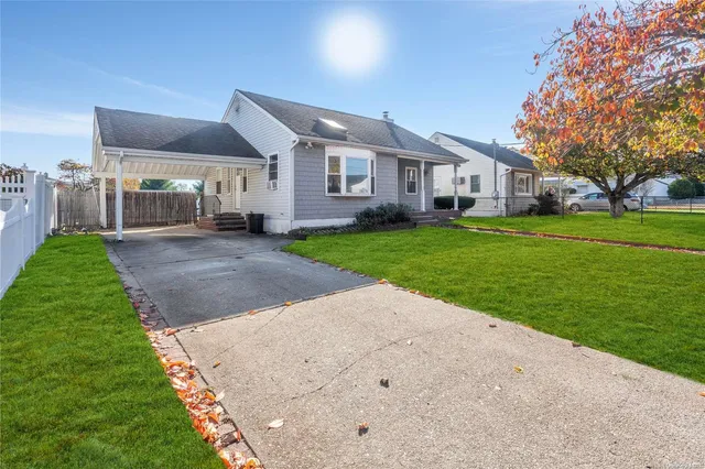 a front view of a house with a yard and trees