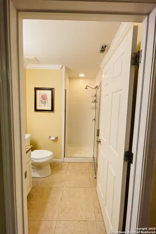 a bathroom with a granite countertop shower a toilet and a shower