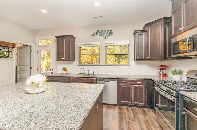a large kitchen with stainless steel appliances granite countertop a stove oven and a sink