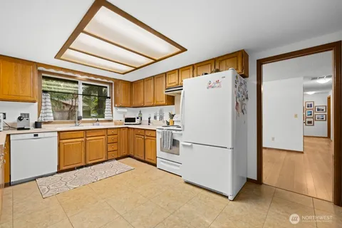 a kitchen with a refrigerator and white cabinets
