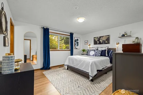 a bedroom with a bed and wooden floor